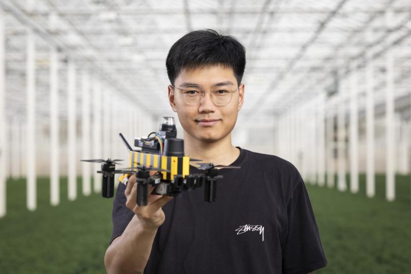 代尔夫特理工大学博士生 Dequan Ou 与 Bee-Nav 无人机。图片来源:代尔夫特理工大学微型飞行器实验室
